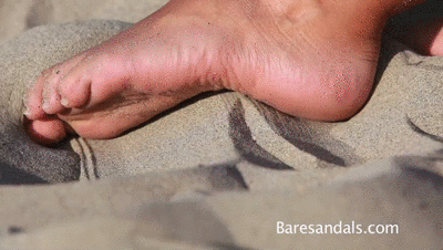 183728 - Cassandra playfully plays the sand with her feet on the beach - Video update 13138